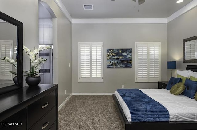 carpeted bedroom with arched walkways, baseboards, and ornamental molding