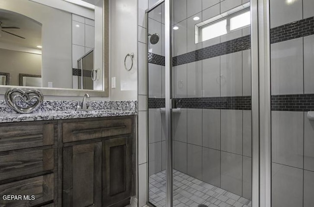 bathroom featuring vanity, a ceiling fan, and a stall shower