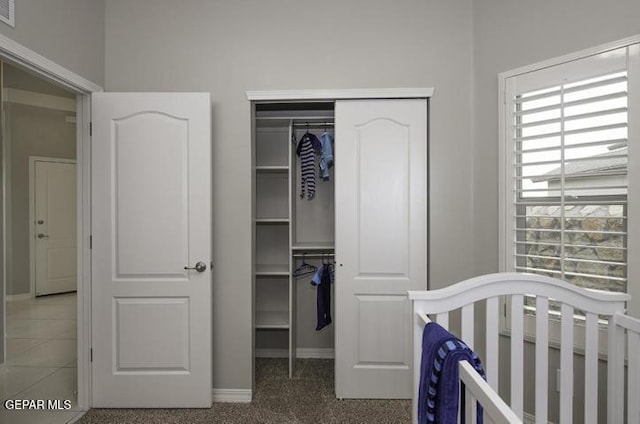 bedroom featuring a closet, multiple windows, and a nursery area