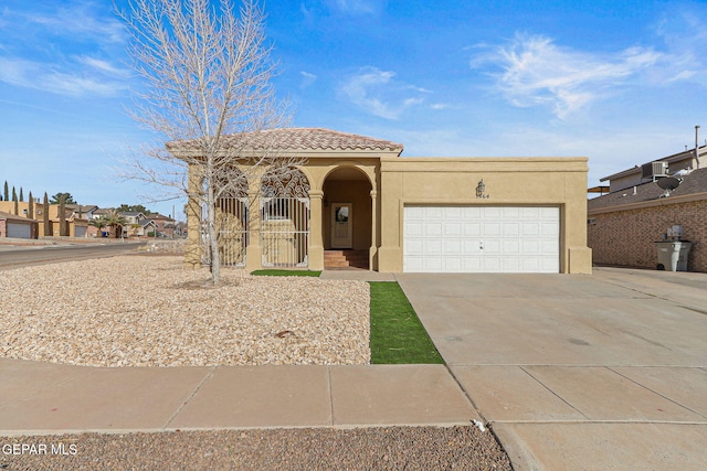 mediterranean / spanish house featuring a tile roof, stucco siding, driveway, and an attached garage