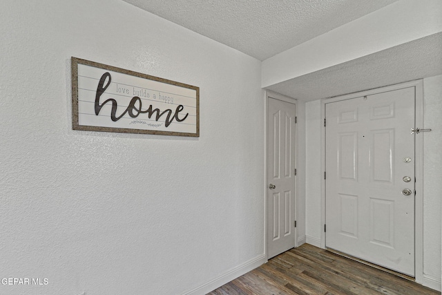 interior space with baseboards, a textured ceiling, wood finished floors, and a textured wall