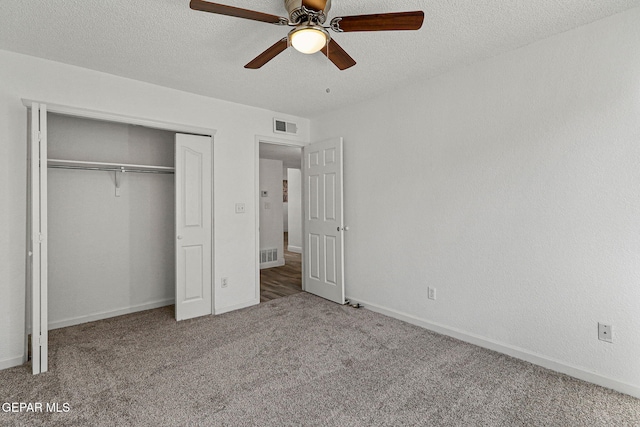 unfurnished bedroom with carpet flooring, visible vents, a closet, and a textured ceiling