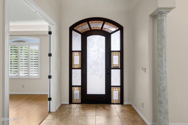 entrance foyer with baseboards and ornate columns