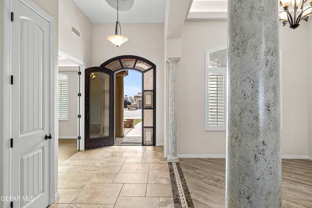 entrance foyer with plenty of natural light, baseboards, and decorative columns