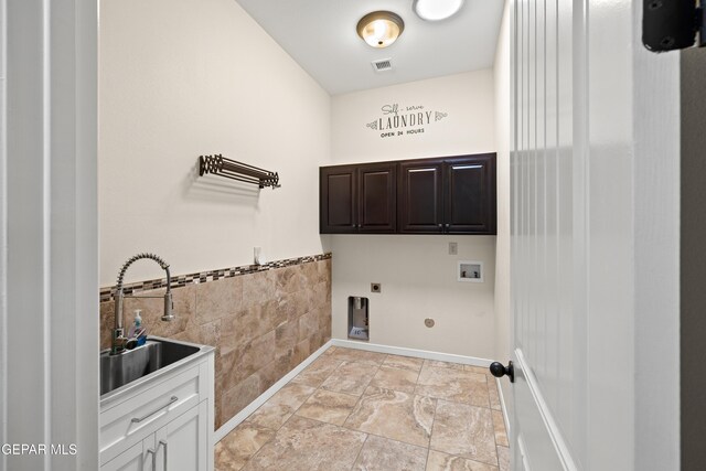 laundry room featuring cabinet space, hookup for an electric dryer, tile walls, washer hookup, and wainscoting