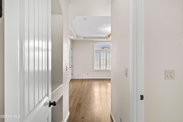 hallway with wood-type flooring and baseboards