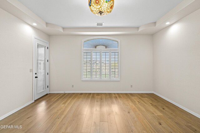 empty room featuring recessed lighting, light wood-type flooring, and baseboards