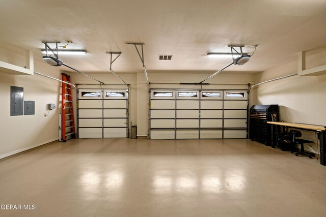 garage with a garage door opener and electric panel