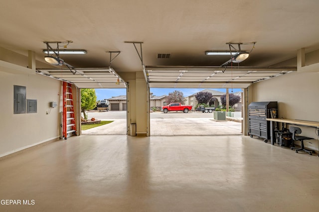 garage with electric panel and baseboards