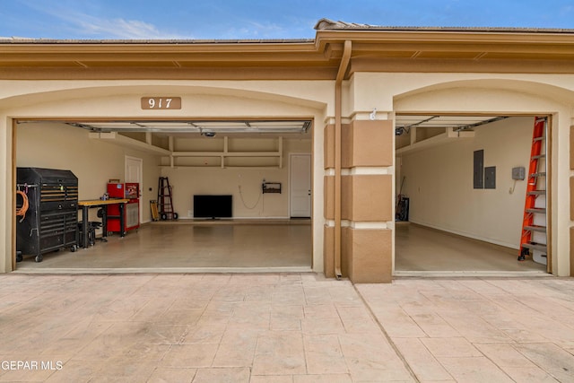 garage featuring driveway and electric panel