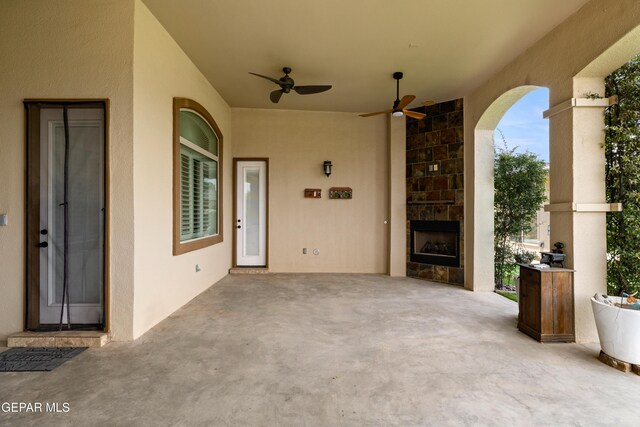 view of patio / terrace featuring a fireplace and a ceiling fan