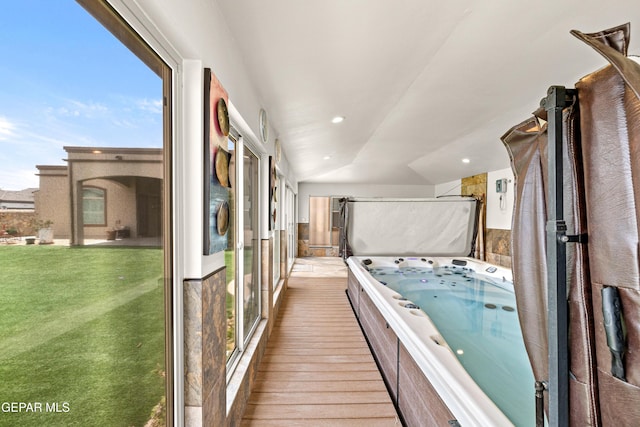 unfurnished sunroom featuring a hot tub and vaulted ceiling