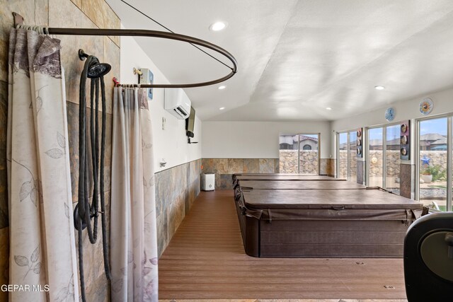 rec room featuring wainscoting, wood finished floors, recessed lighting, and lofted ceiling