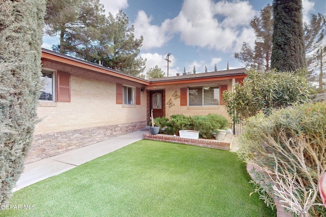 view of front of home featuring brick siding and a front yard