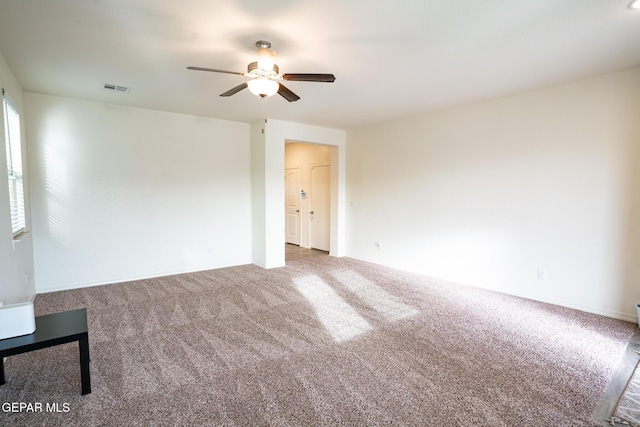 unfurnished room with visible vents, carpet, and a ceiling fan