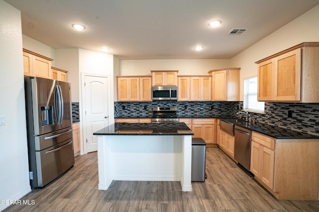 kitchen with visible vents, light brown cabinets, a sink, wood finished floors, and stainless steel appliances