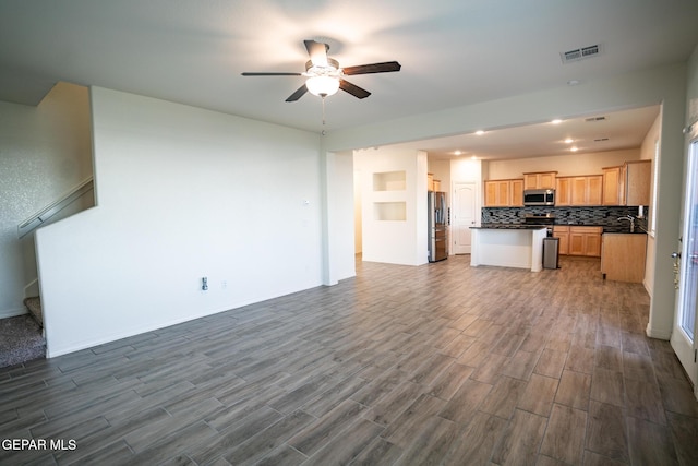 kitchen featuring visible vents, ceiling fan, appliances with stainless steel finishes, dark countertops, and open floor plan