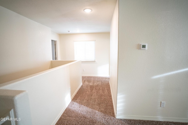 hallway with baseboards and carpet floors