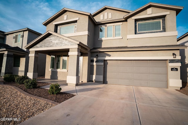 view of front facade featuring a garage, driveway, and stucco siding