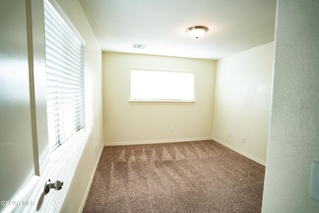 carpeted empty room with visible vents and baseboards