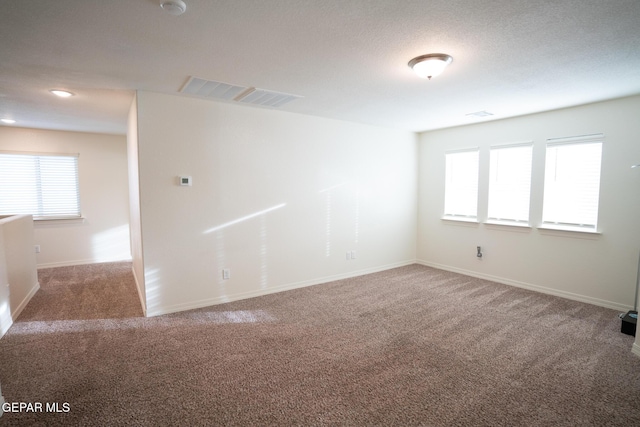 spare room with visible vents, carpet flooring, and baseboards