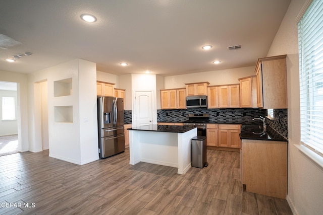 kitchen with visible vents, tasteful backsplash, dark countertops, wood finished floors, and appliances with stainless steel finishes