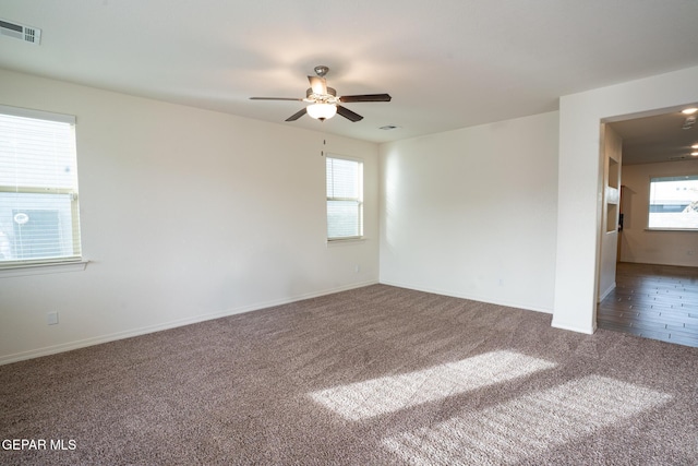 unfurnished room featuring visible vents, baseboards, carpet, and a ceiling fan