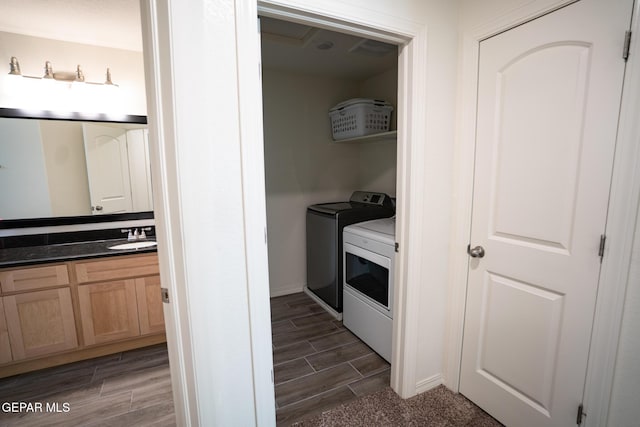 washroom featuring wood finish floors, independent washer and dryer, laundry area, and a sink