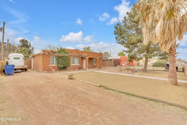 southwest-style home with fence and stucco siding