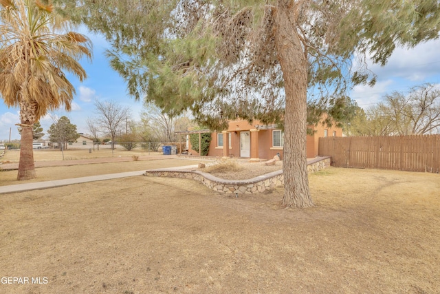 exterior space featuring stucco siding and fence