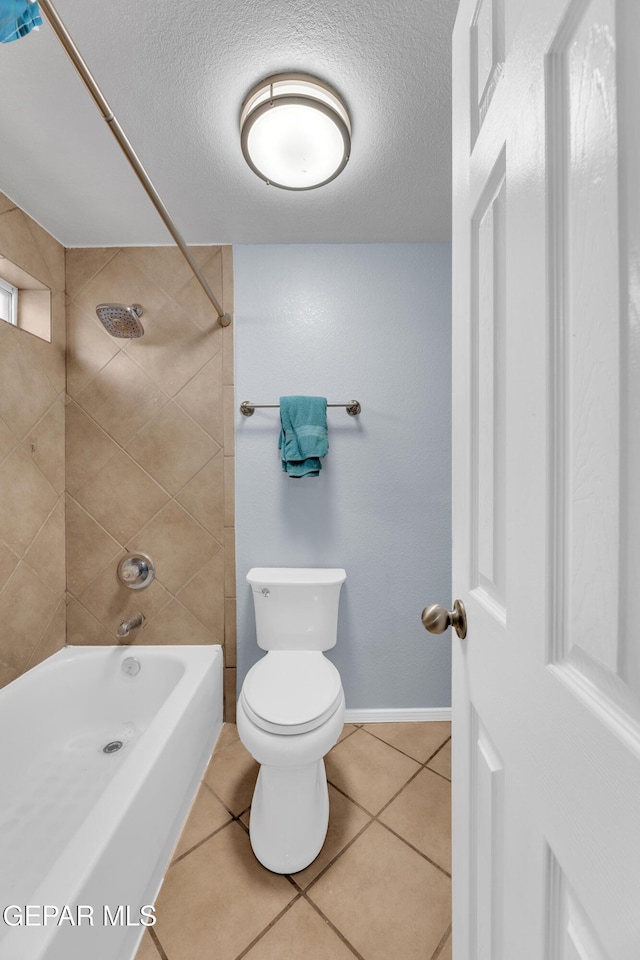 full bathroom with tile patterned flooring, a textured ceiling, toilet, and shower / washtub combination