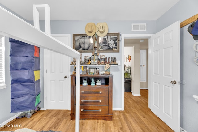 interior space featuring visible vents, baseboards, and wood finished floors