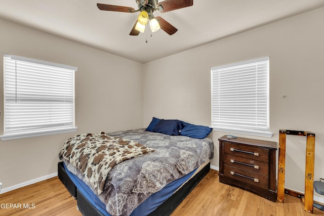 bedroom featuring a ceiling fan, baseboards, and wood finished floors