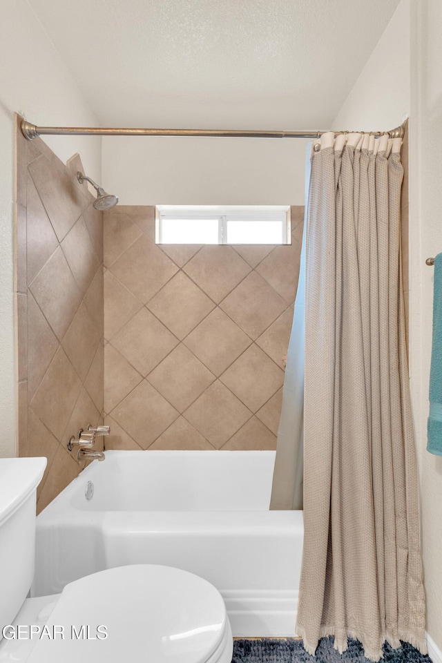 full bathroom featuring a textured ceiling, toilet, and shower / tub combo