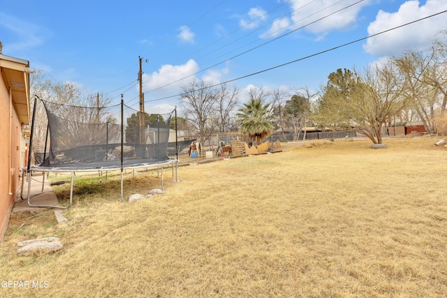 view of yard featuring a trampoline and a fenced backyard