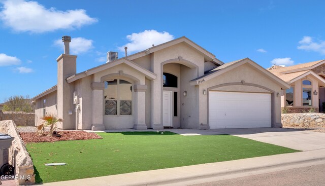 view of front of property featuring driveway, stucco siding, a chimney, a front lawn, and a garage