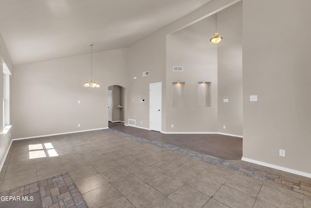 unfurnished living room with arched walkways, visible vents, a chandelier, and baseboards