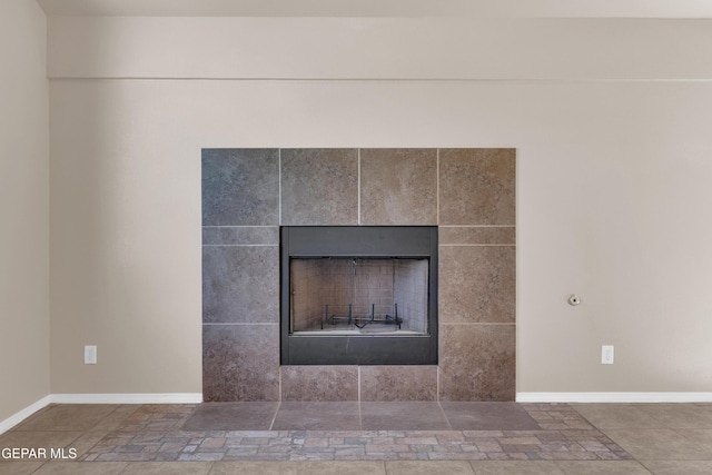 details with a tile fireplace and baseboards