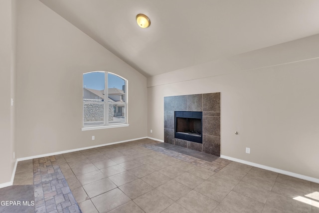 unfurnished living room with lofted ceiling, baseboards, tile patterned floors, and a tile fireplace