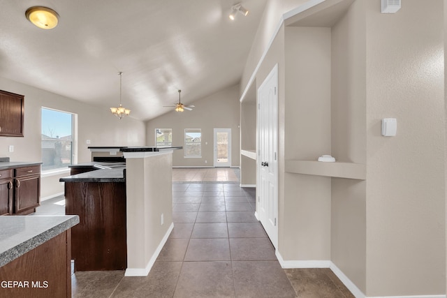 kitchen with a center island, tile patterned flooring, baseboards, vaulted ceiling, and hanging light fixtures