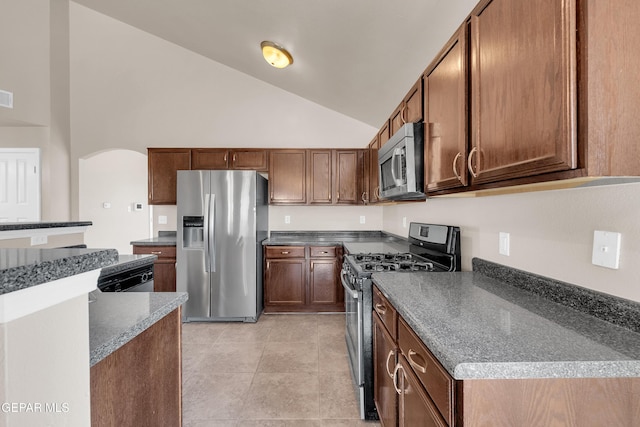 kitchen with dark countertops, visible vents, arched walkways, and appliances with stainless steel finishes