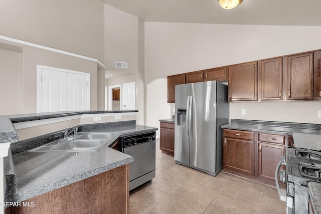 kitchen featuring visible vents, high vaulted ceiling, arched walkways, a sink, and stainless steel appliances