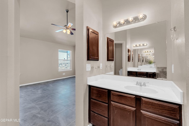 bathroom featuring a ceiling fan, tile patterned flooring, baseboards, vanity, and vaulted ceiling