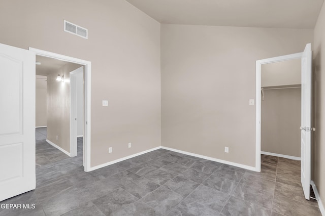 unfurnished bedroom featuring a spacious closet, visible vents, a closet, and baseboards