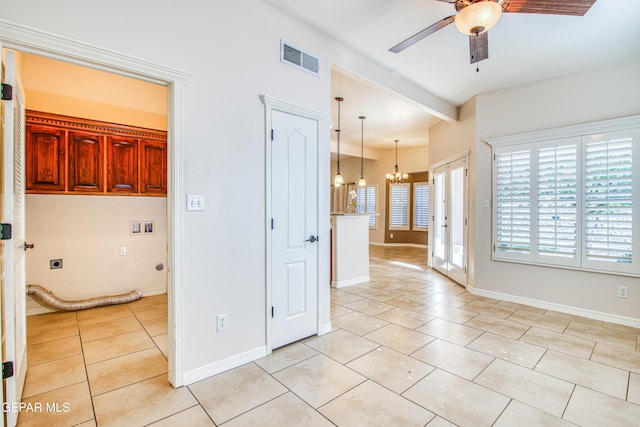 interior space with ceiling fan with notable chandelier, light tile patterned flooring, baseboards, and visible vents