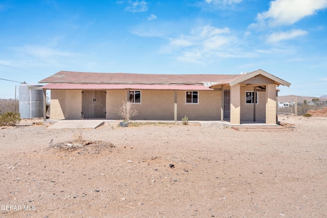 ranch-style house with stucco siding and a patio area