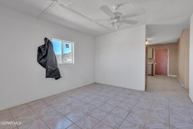 spare room featuring a textured ceiling and a ceiling fan