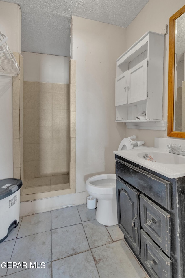 full bath featuring a stall shower, toilet, vanity, and a textured ceiling