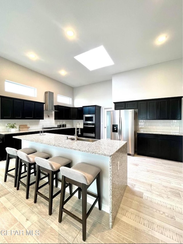 3897 Surmise St, El Paso, TX 79938 - kitchen featuring stainless steel fridge with ice dispenser, a sink, wall chimney range hood, decorative backsplash, and recessed lighting