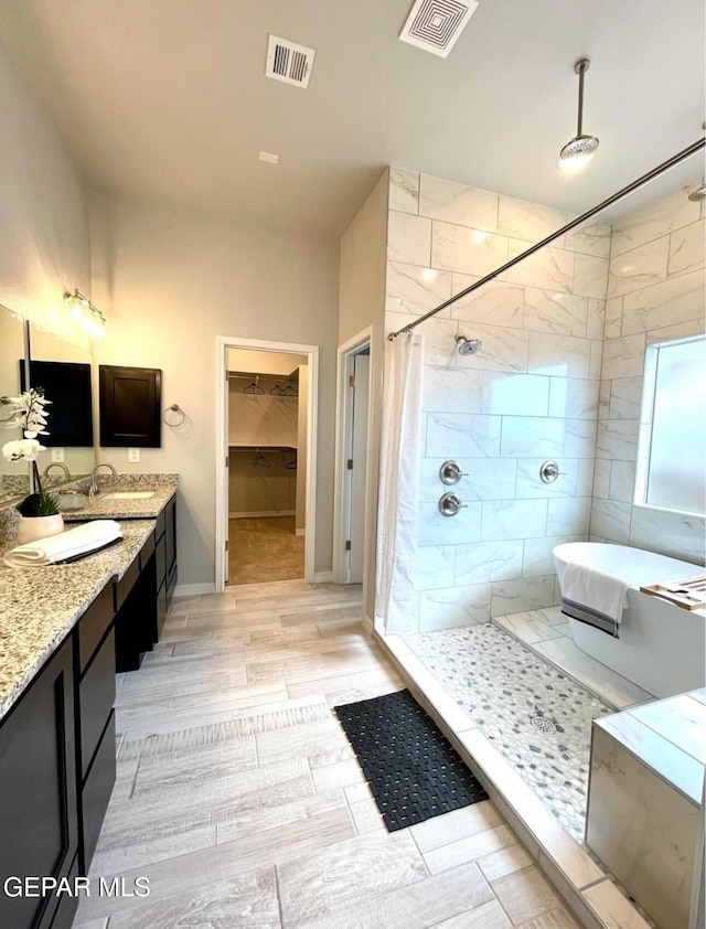 3897 Surmise St, El Paso, TX 79938 - full bathroom featuring a tile shower, double vanity, baseboards, and a walk in closet